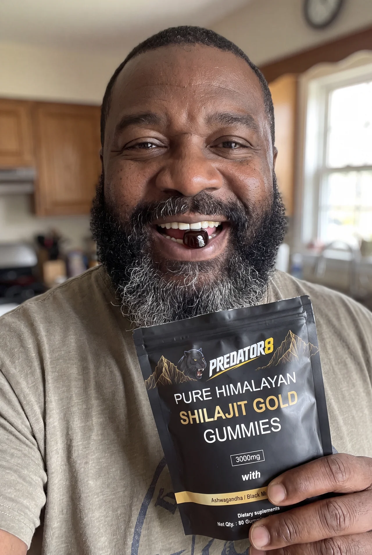 Marcus holding a PREDATOR8 Shilajit Gold pouch in his kitchen