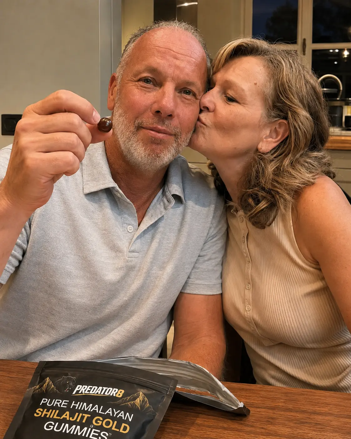 Man holding a shilajit gummy while his wife kisses his cheek