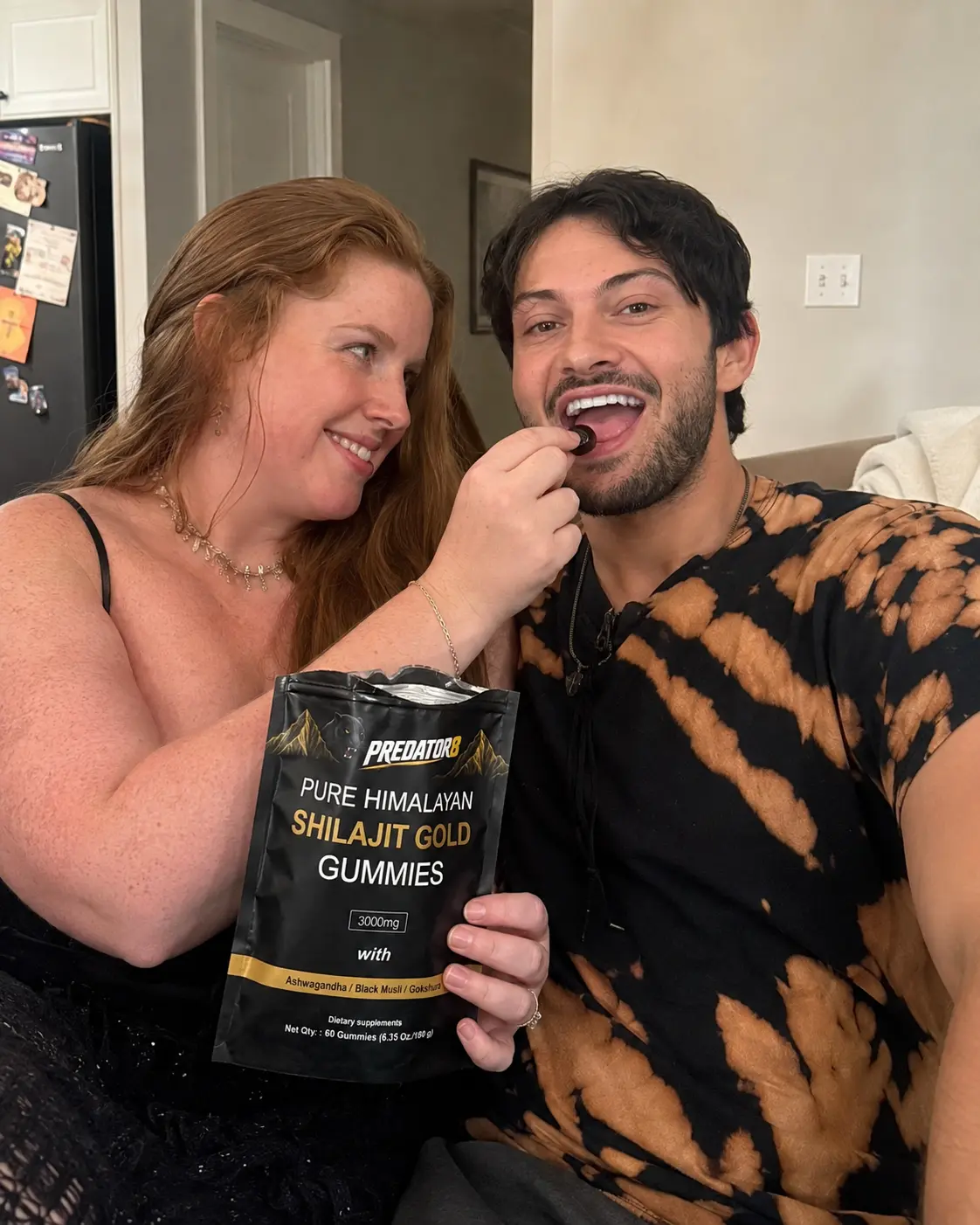 Woman feeding her partner a shilajit gummy on the couch
